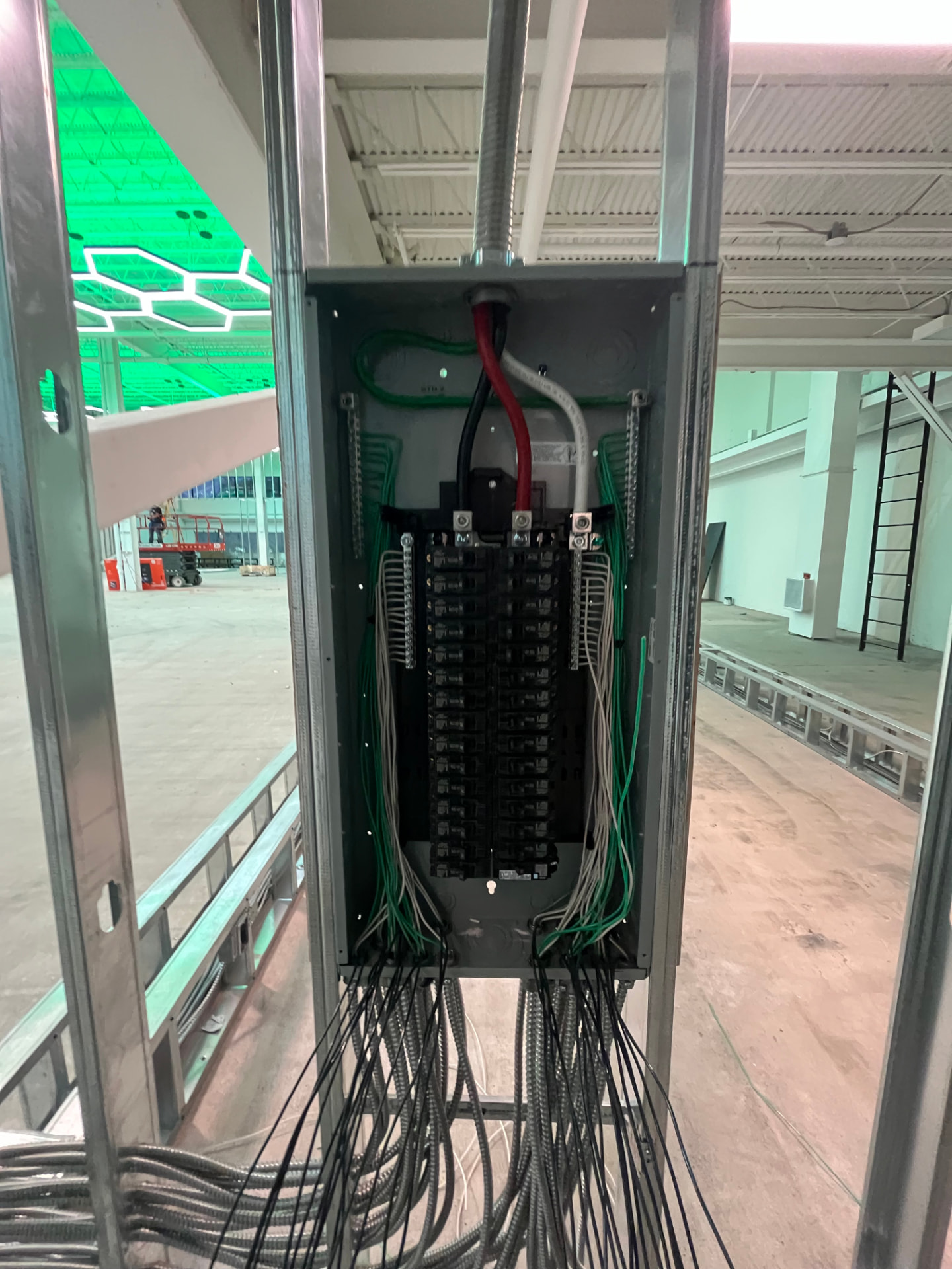 Tenant branch panel installed and wired with labeled MC cable homeruns during rough-in