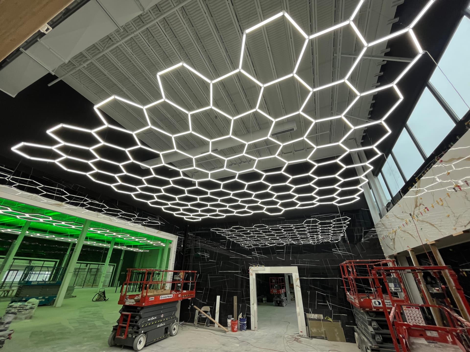 Finished hexagon LED ceiling grid across an open commercial space